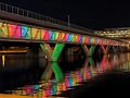 Valley Metro Rail bridge over Tempe Town Lake with rainbow lights. Photo from Tempe Tourism